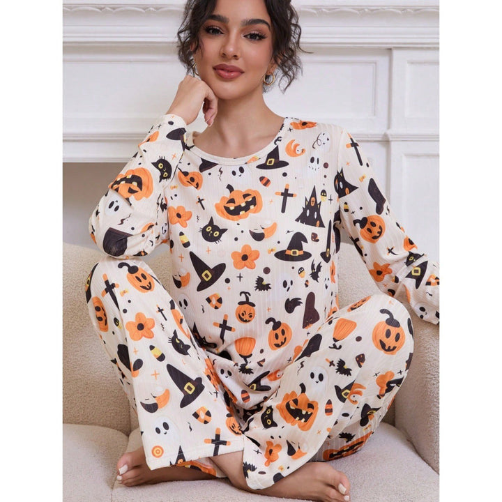 Woman poses in Halloween pajama set with jack-o-lantern and black cat print