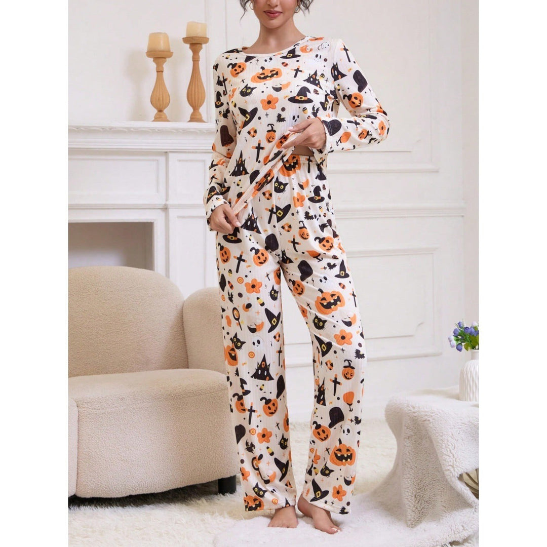 Woman stands showcasing wide-leg pajama pants with orange pumpkin and bat print
