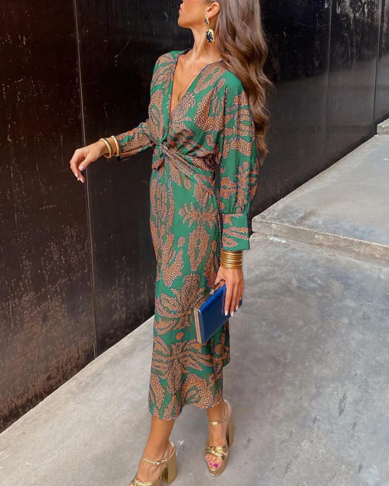 Green paisley midi dress paired with gold heels and a blue clutch bag