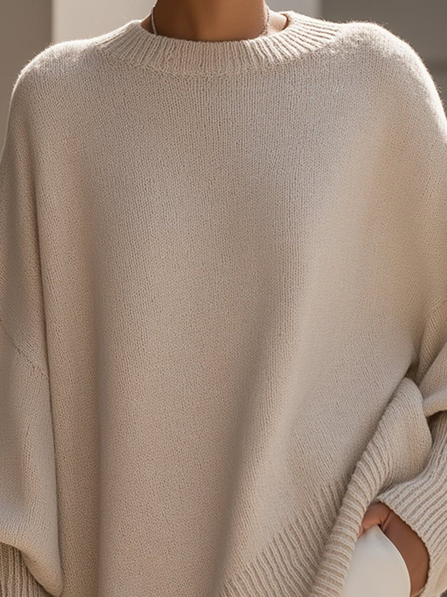 Close-up of beige knit crew neckline on oversized batwing sweater