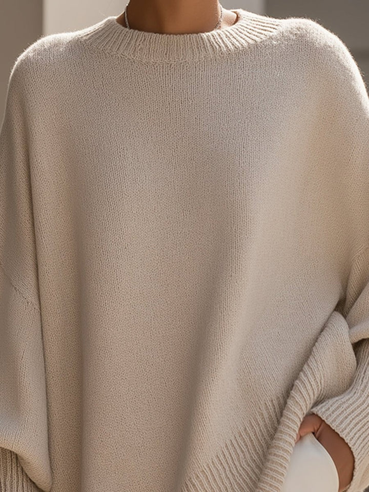 Close-up of beige knit crew neckline on oversized batwing sweater