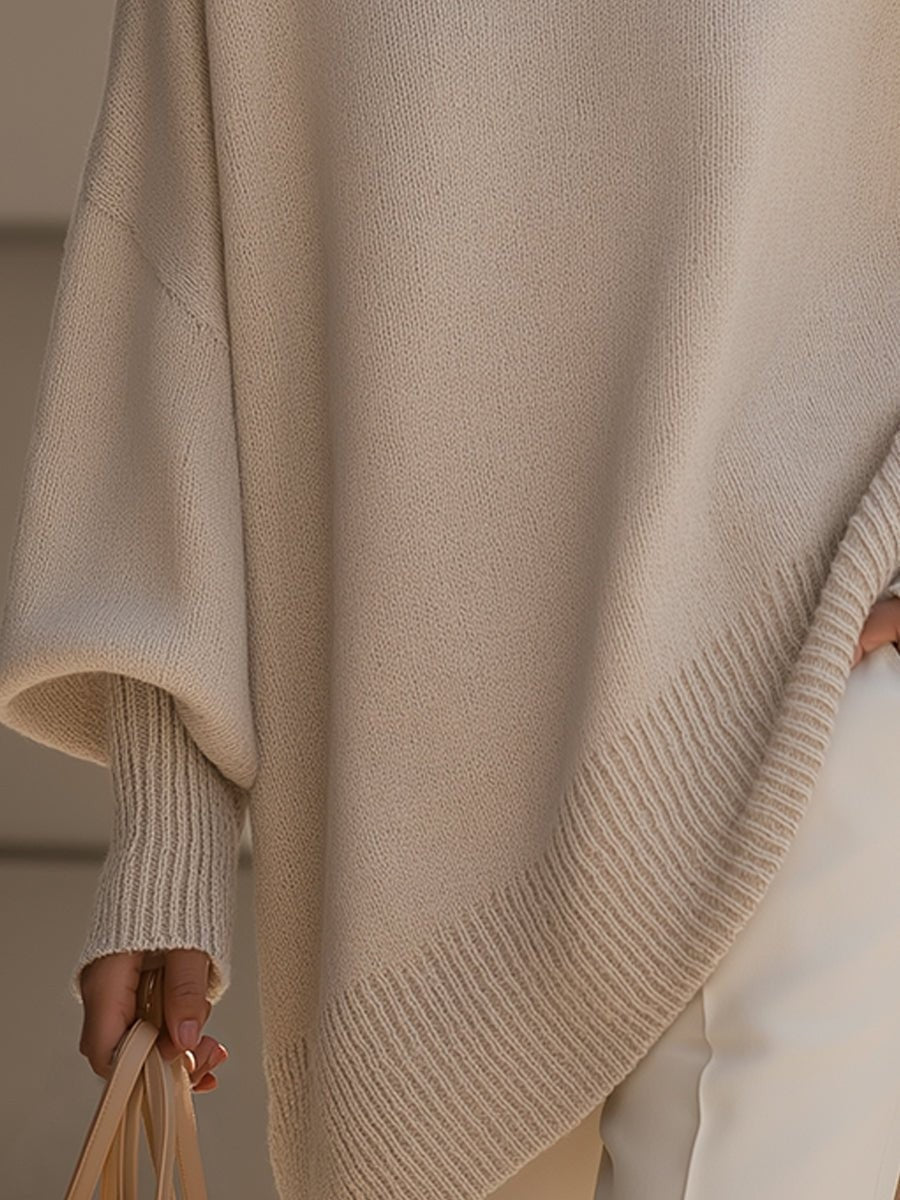 Detail shot of ribbed asymmetric hem on beige longline knit sweater