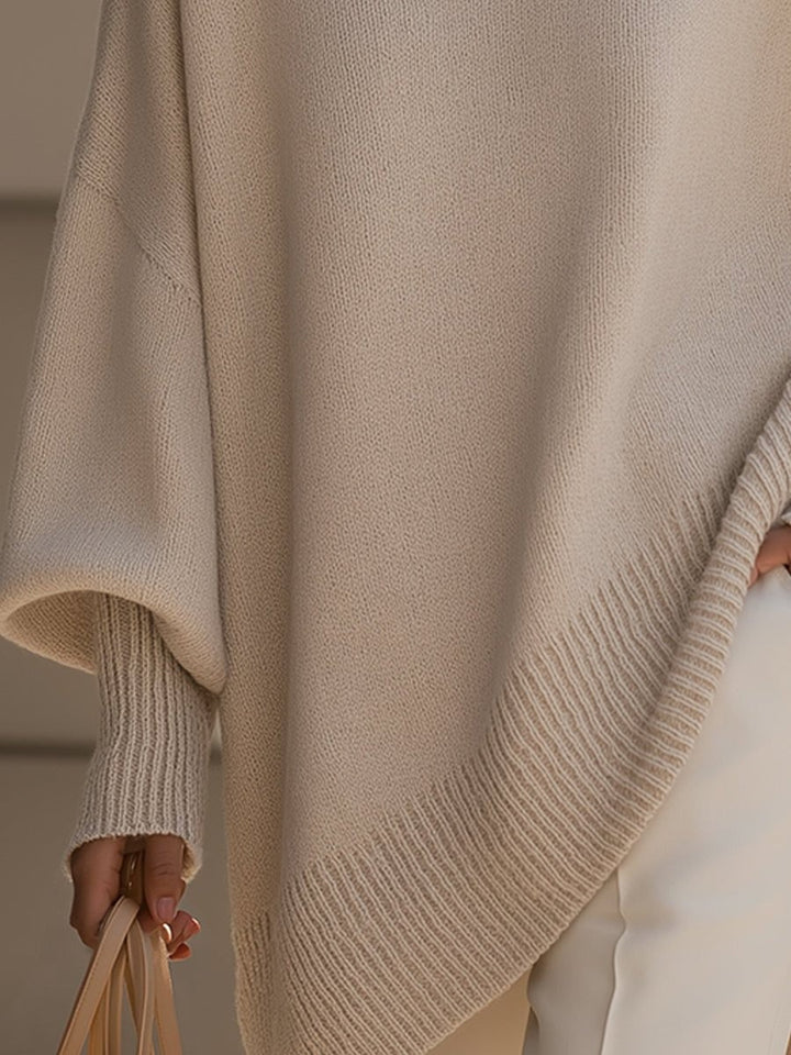 Detail shot of ribbed asymmetric hem on beige longline knit sweater