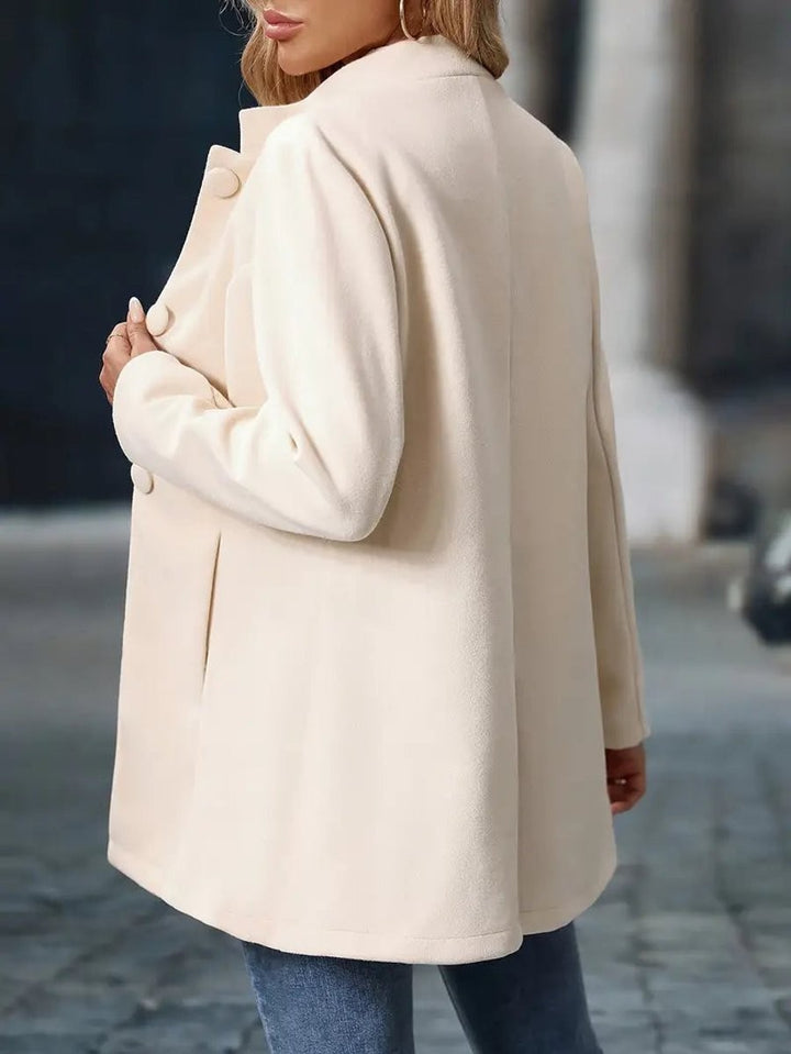 back view of ivory coat blazer highlighting stand collar and seam detail