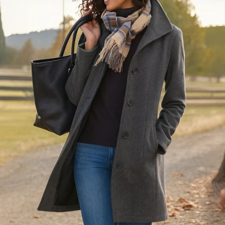 Charcoal gray mid-length wool-blend coat paired with jeans and black tote