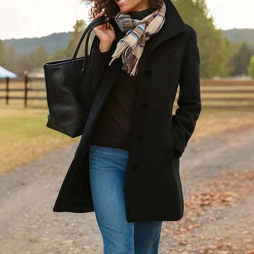 Black mid-length wool-blend coat styled with jeans and leather tote bag