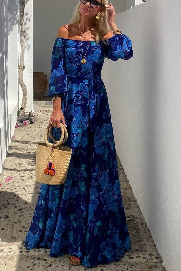 Off-shoulder blue floral maxi dress paired with a straw handbag for a wedding guest look