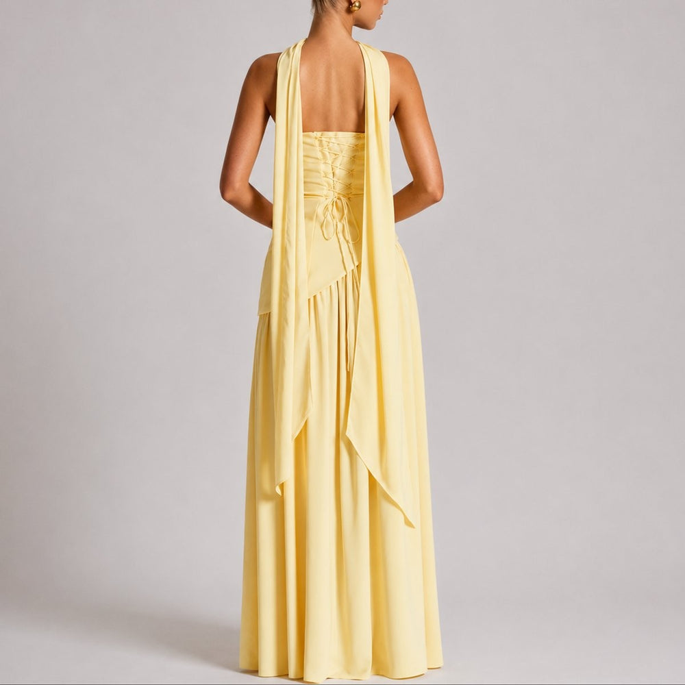 Back view of yellow strapless gown showing lace-up corset and draped scarf straps