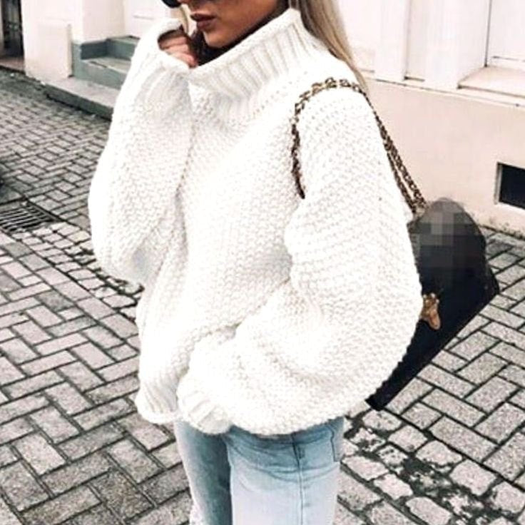 White oversized chunky knit turtleneck sweater paired with distressed denim jeans