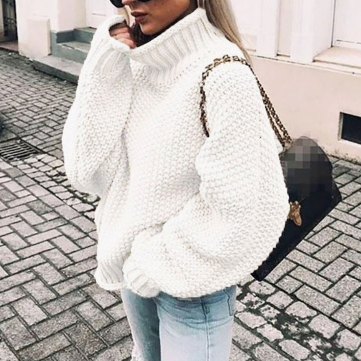 Ivory oversized chunky knit turtleneck sweater worn with ripped skinny jeans
