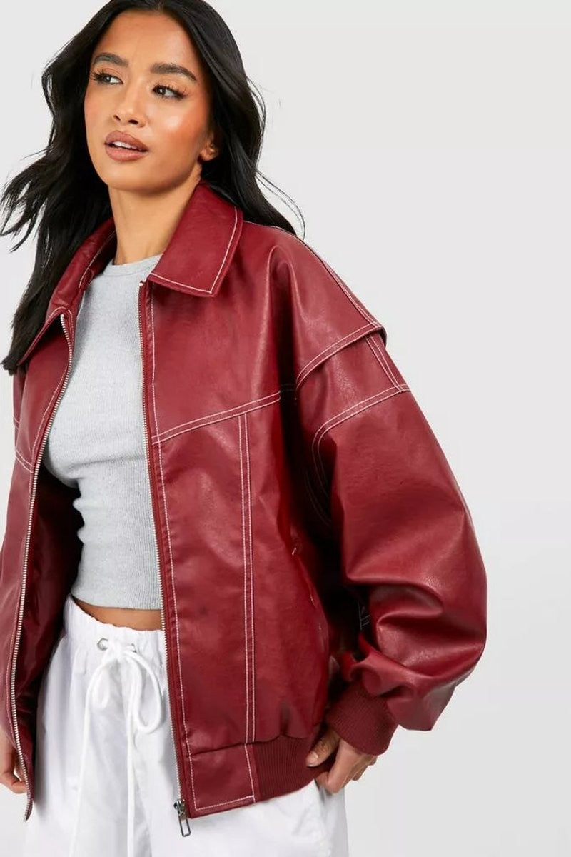 Close-up of oxblood faux leather bomber jacket with contrast stitching on model