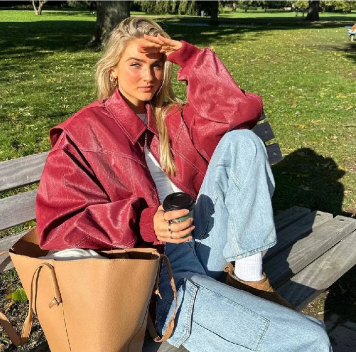 Burgundy oversized bomber jacket paired with wide-leg jeans and a tote bag
