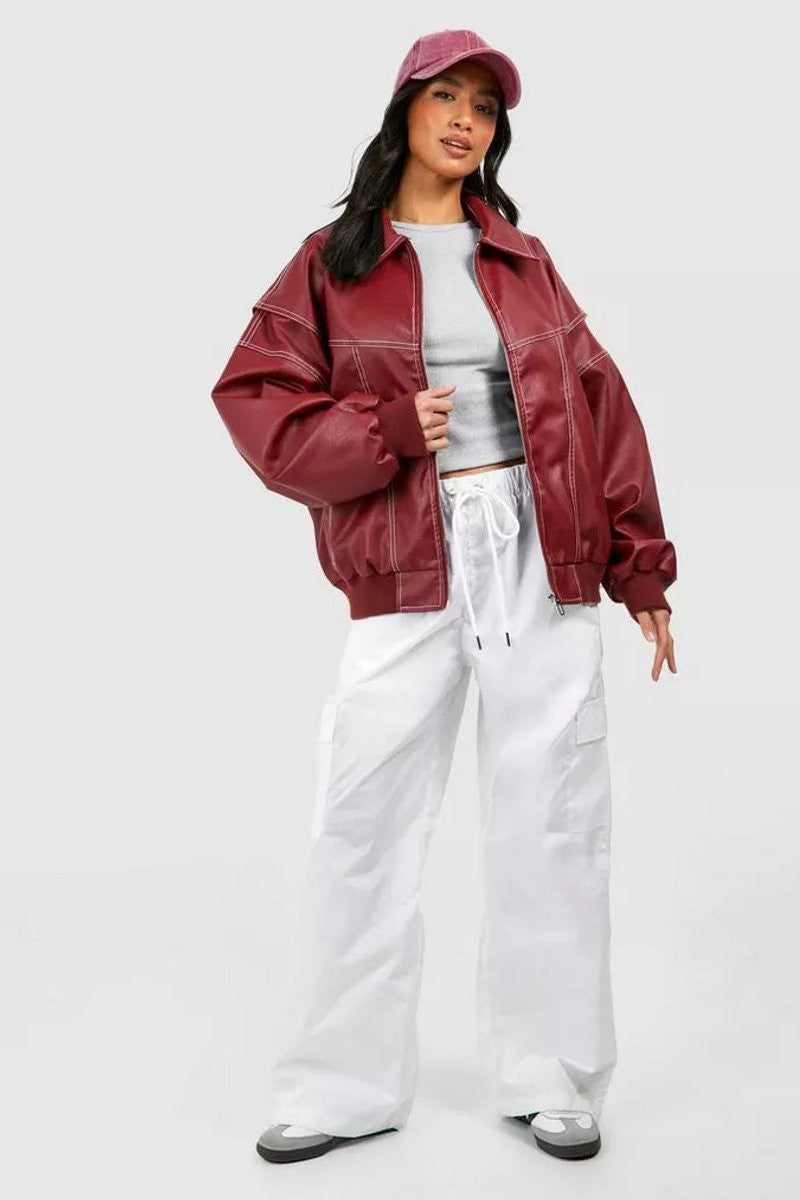Oversized burgundy bomber jacket worn with white cargo pants and matching cap