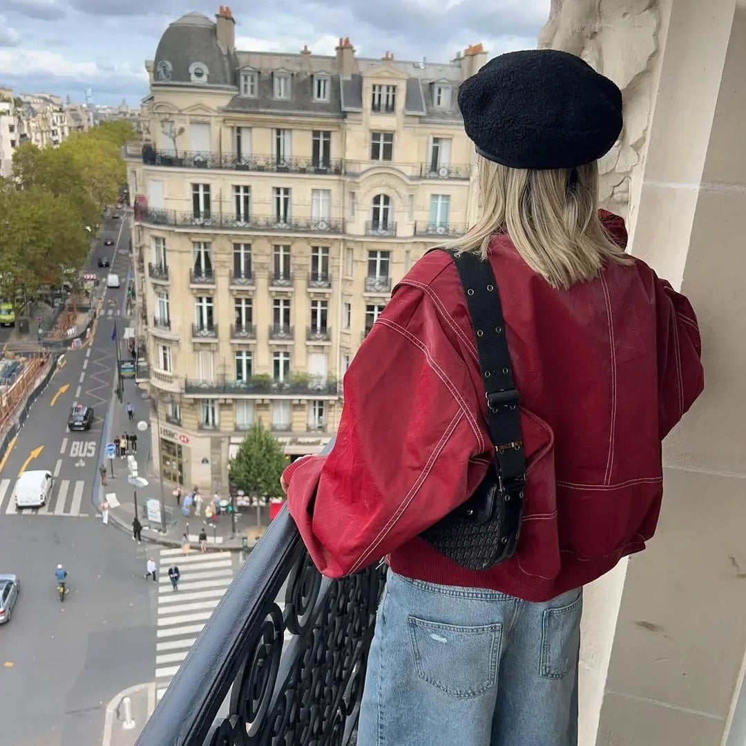 Back view of oversized red leather bomber jacket with crossbody bag detail