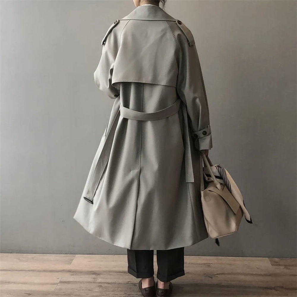 Back view of oversized belted trench coat showing raglan sleeves and long silhouette