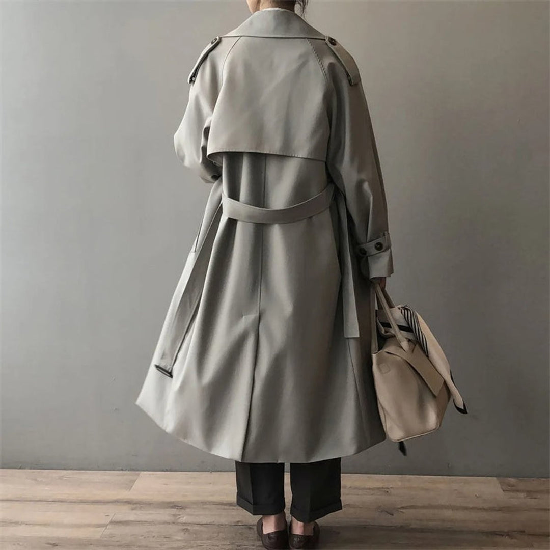 Back view of oversized belted trench coat showing raglan sleeves and long silhouette