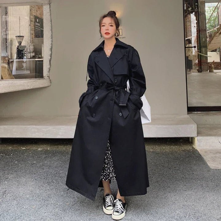 Black oversized double-breasted trench coat with tie waist, full-length view