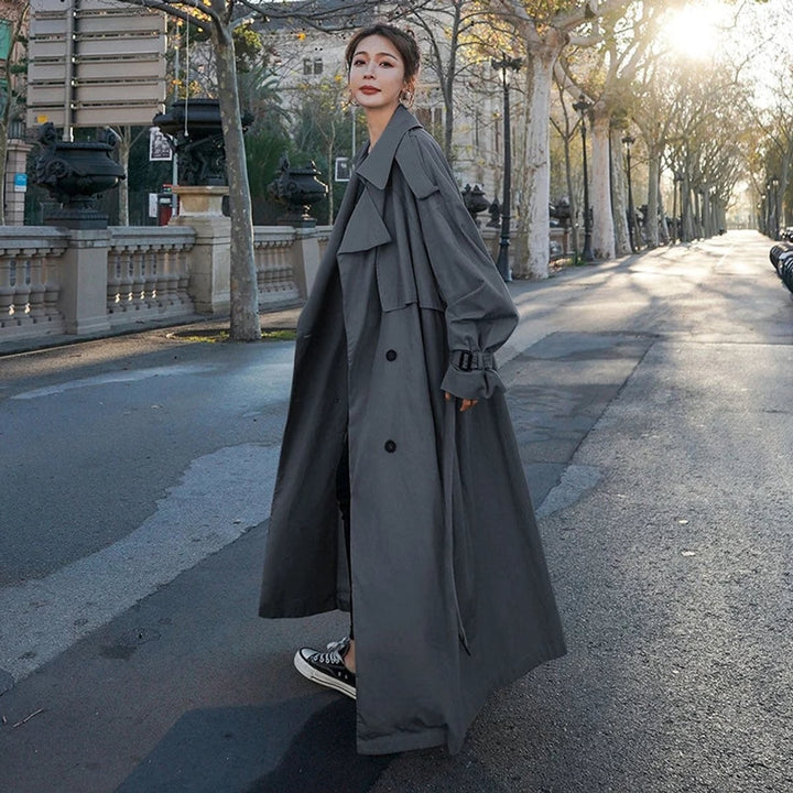Gray belted trench coat, side view showing long flowing silhouette