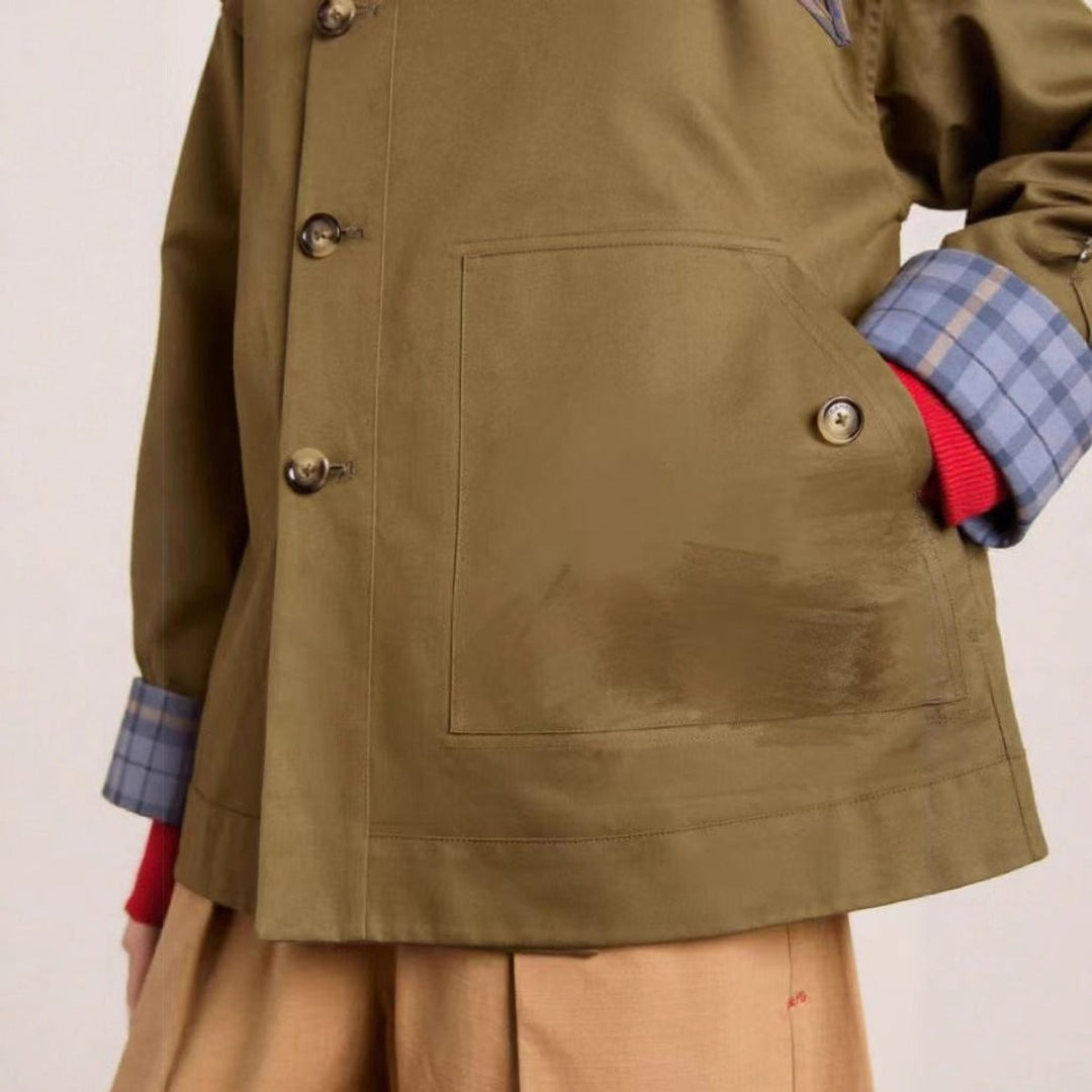 close-up of olive trench coat patch pocket and plaid cuff lining