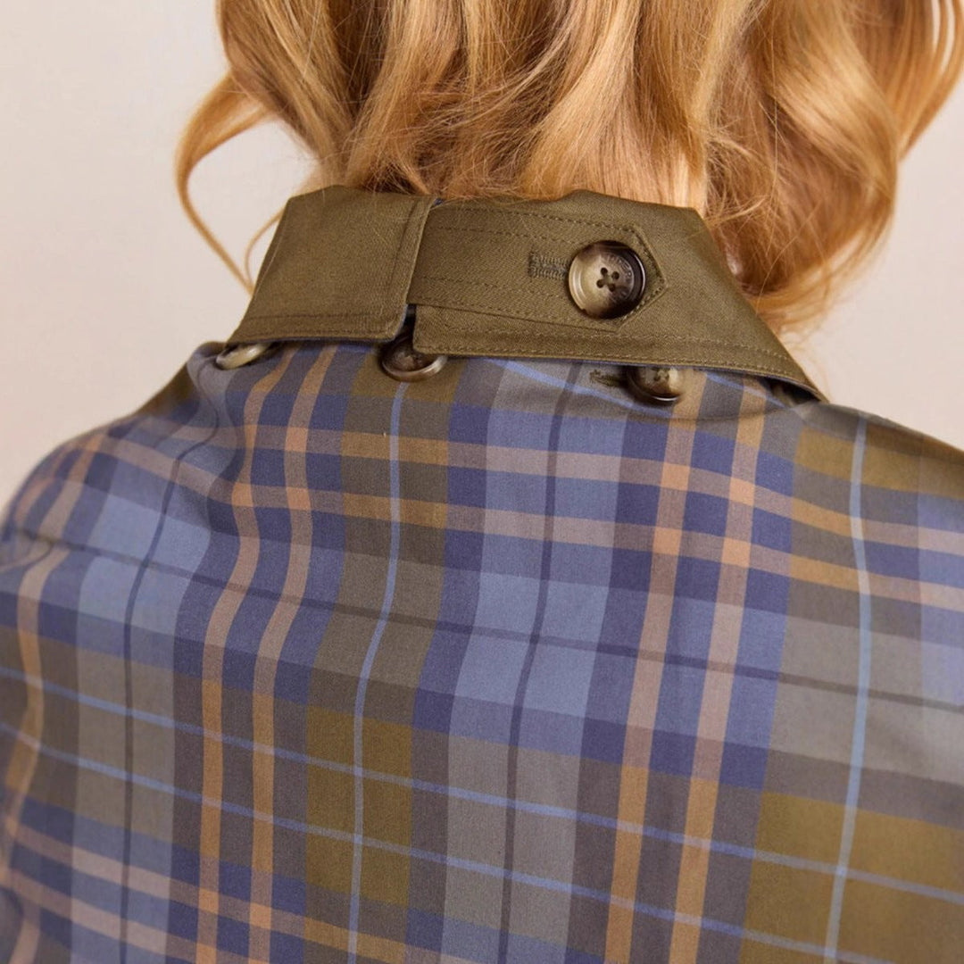 detail of olive coat collar button strap with plaid interior fabric