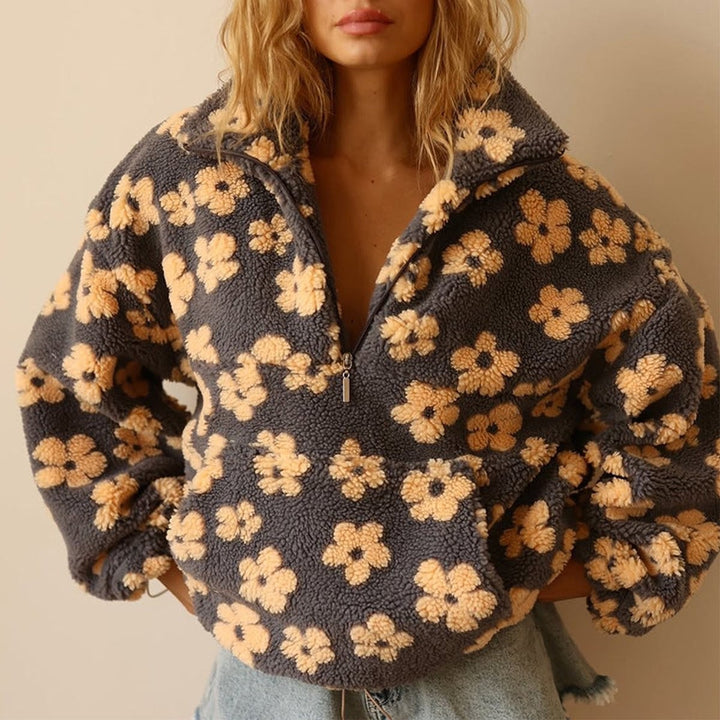 close-up of gray sherpa half-zip pullover with mustard flower pattern and front pocket
