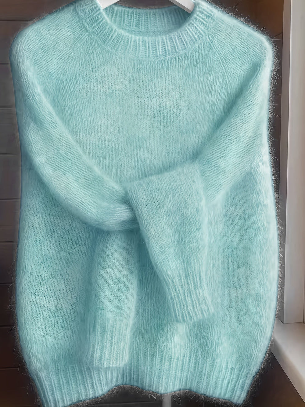 Mint green fuzzy knit sweater with ribbed cuffs on hanger