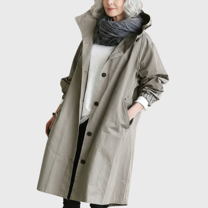 Taupe oversized hooded trench coat worn with a chunky gray scarf