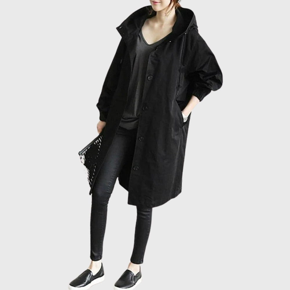 Black oversized hooded long trench coat paired with skinny jeans