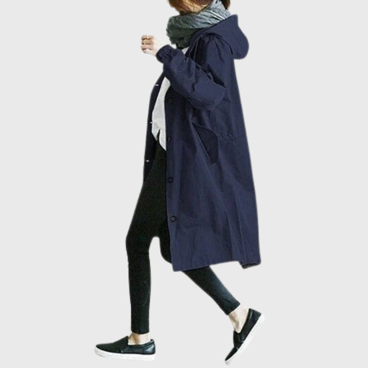 Navy hooded long trench coat worn in motion with black leggings
