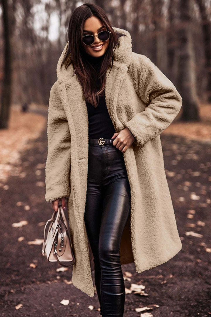 Beige hooded teddy coat paired with black leather pants and a handbag