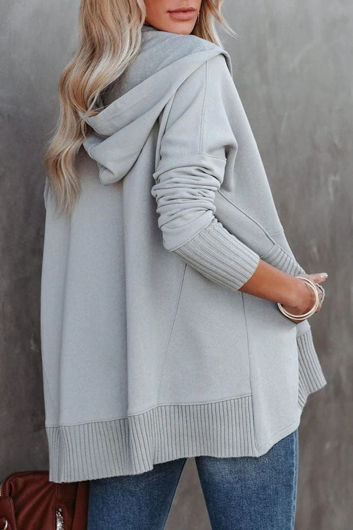 Back view of gray oversized hoodie with hood and ribbed sleeve cuffs