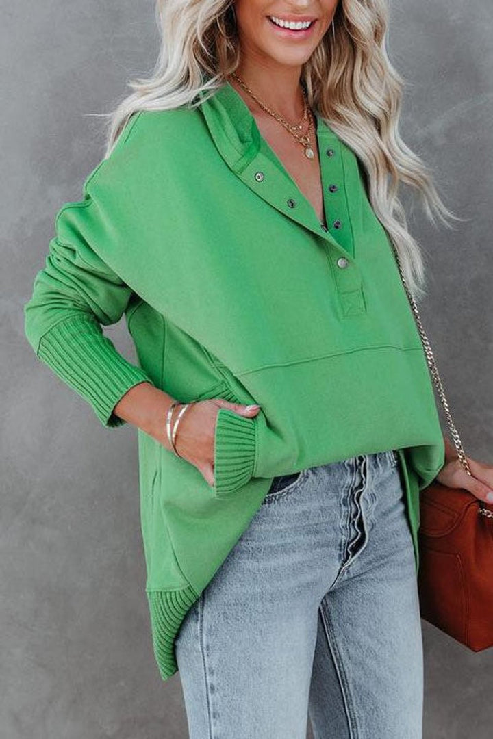 Green snap-front hoodie styled with ripped jeans and a crossbody bag