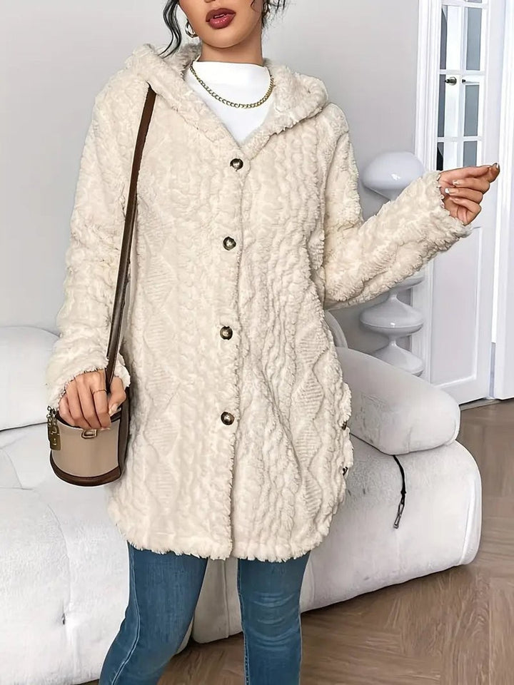 Cream fleece hooded cardigan draped over shoulder with textured knit pattern