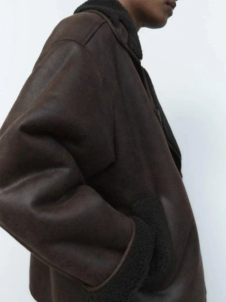Close-up of brown leather sleeve with black shearling trim and pocket