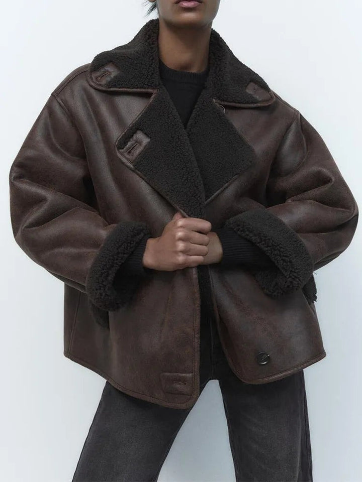 Model wearing oversized brown leather jacket with black shearling collar