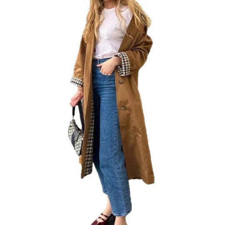 Camel oversized trench coat with plaid-lined sleeves worn over jeans