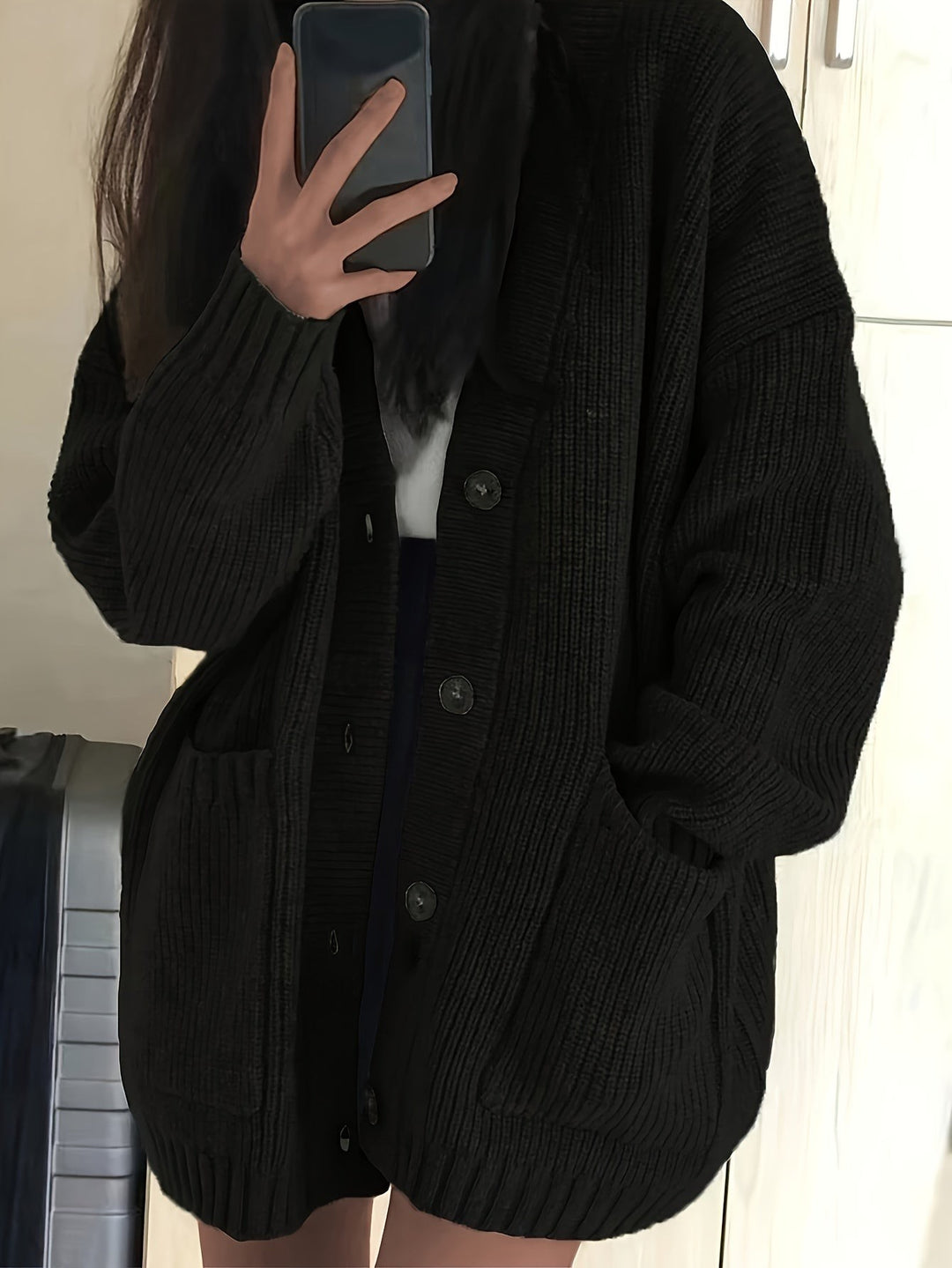 Black ribbed cardigan with oversized fit and dark button details