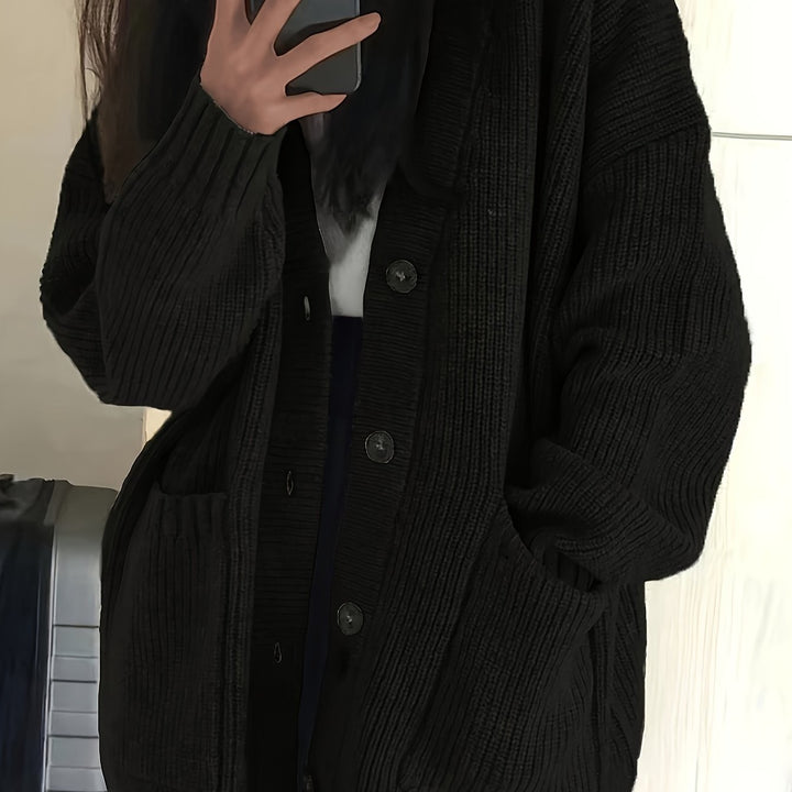 Close-up of black ribbed cardigan showing button-front closure detail