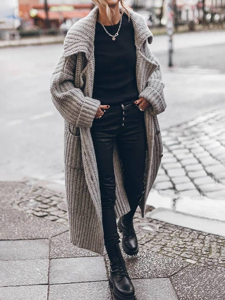 Woman wearing oversized gray knit cardigan with lapel collar and skinny pants