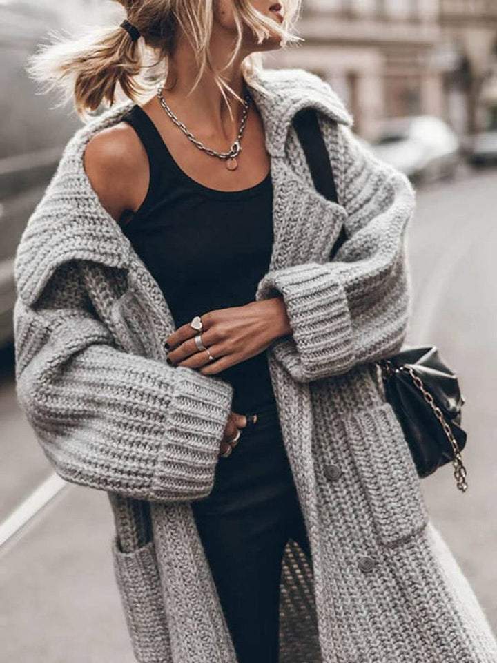 Close-up of oversized gray cable knit cardigan with wide lapel collar