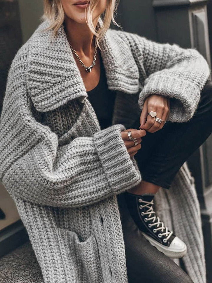 Chunky knit gray cardigan detail showing ribbed sleeves and patch pocket