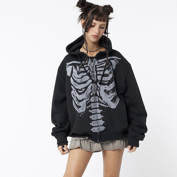 Model wearing black skeleton print zip-up hoodie with grunge style