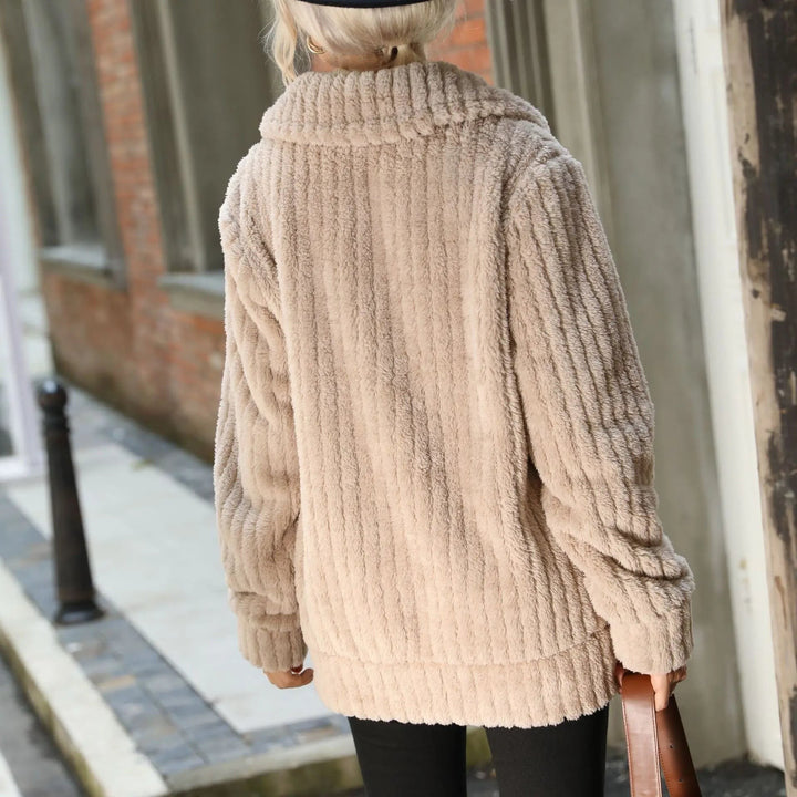 Back view of woman walking in long taupe ribbed faux fur coat