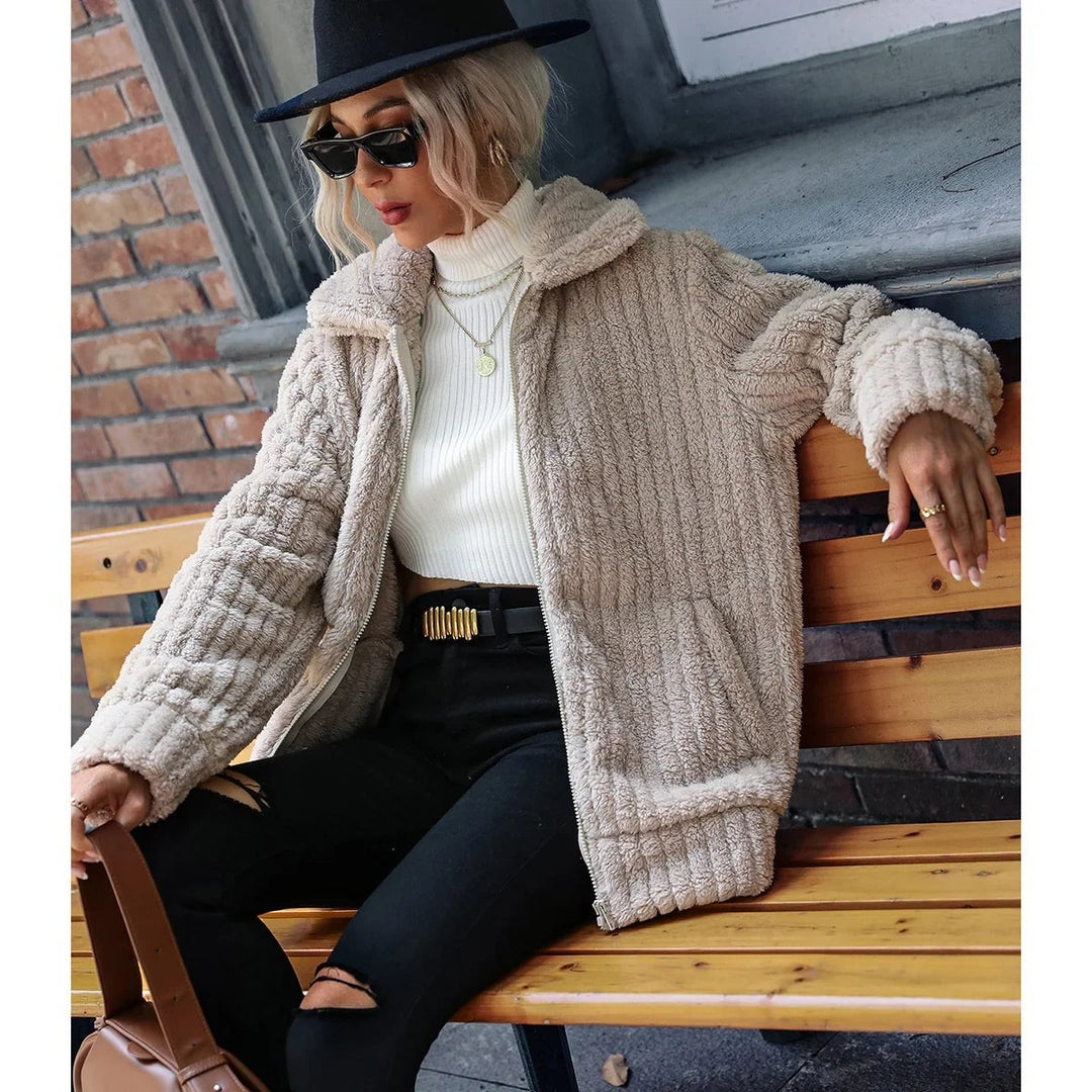 Model seated in beige ribbed faux fur jacket with front pockets