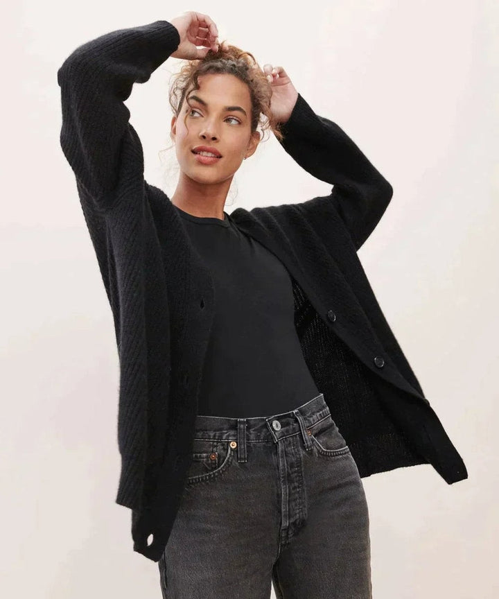 Black ribbed cashmere cardigan layered over a black top and jeans
