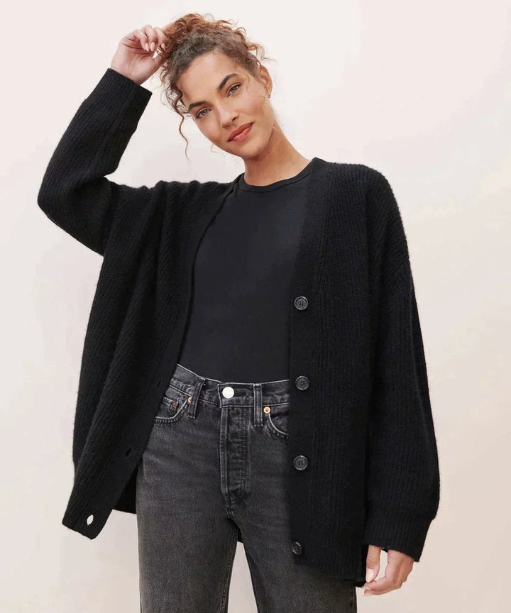 Black button-front cardigan styled with faded black denim jeans