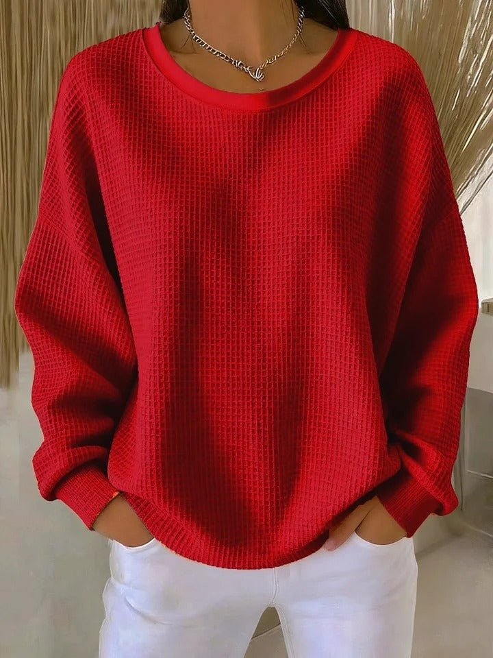 Red waffle-knit oversized sweater featuring long sleeves and crew neckline