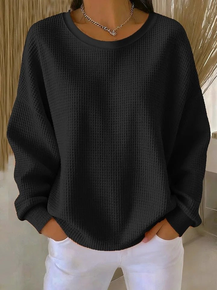 Black waffle-knit oversized sweater with long sleeves and relaxed crew neck