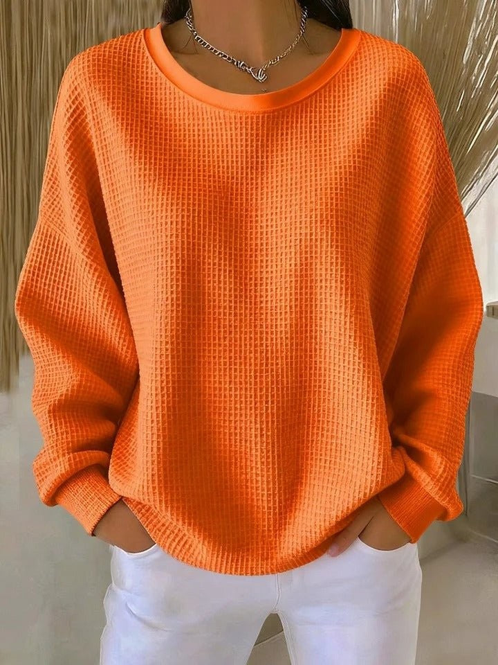 Bright orange waffle-knit pullover sweater with oversized fit and round collar