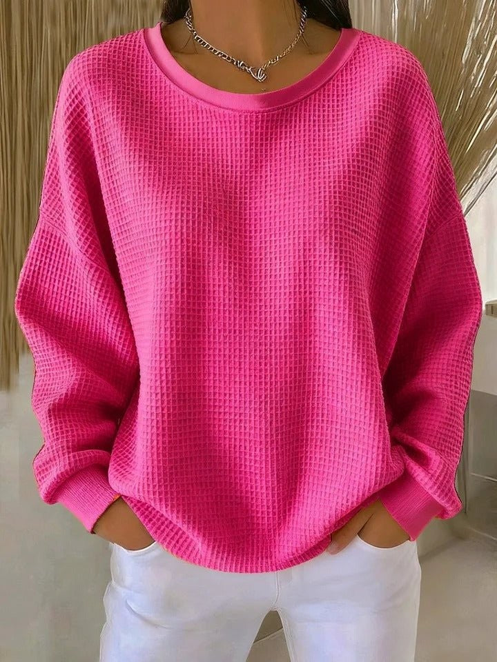 Hot pink waffle-knit oversized sweater with long sleeves and ribbed cuffs